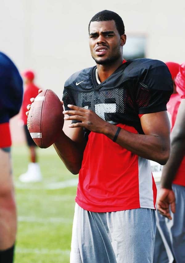 UNM quarterback Donovan Porterie warms up on the sidelines before practice.