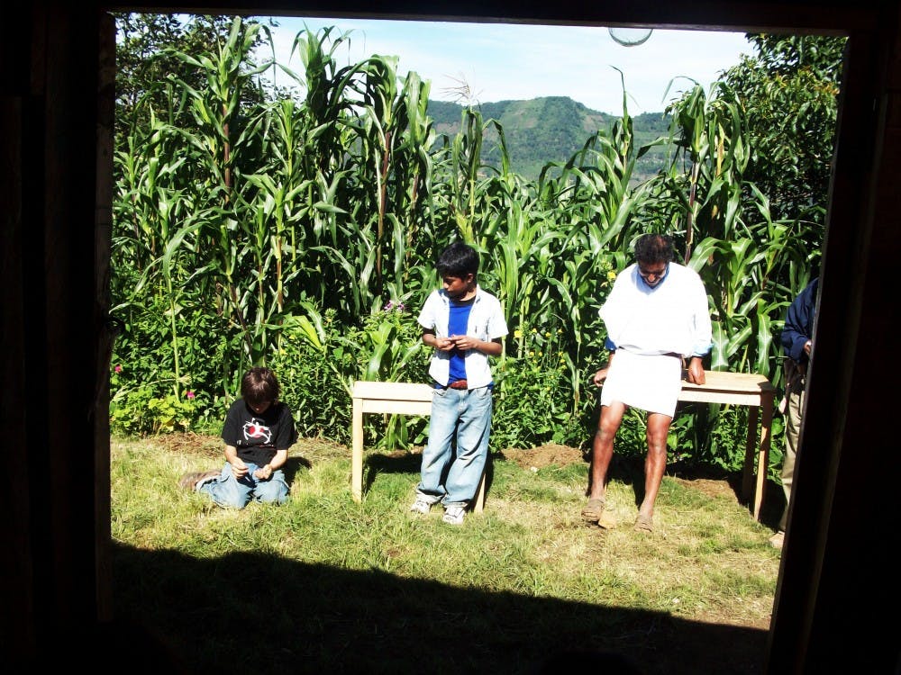 	Two villagers and a young boy sit in the sun in Polhó, Mexico.