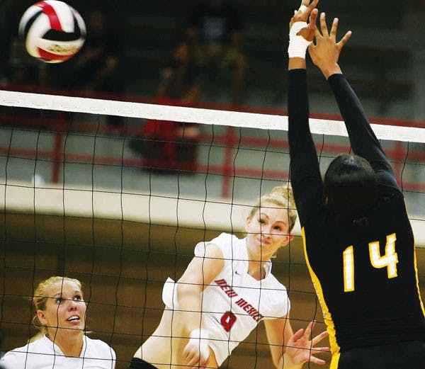 UNM middle back Allie Suiter spikes the ball past Grambling State's Markesha Warner in the third game of the MCM Elegante Lobo Classic on Saturday in Johnson Center. The Lobos won 3-0. 