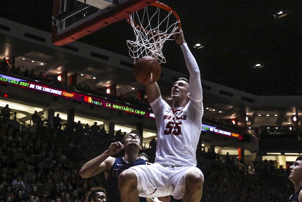 Freshman Connor MacDougall hangs on the rim after a slam dunk against Utep Wedensday, Dec. 7, 2016 at WisePies Arena. The Lobos beat Utep 78-77.