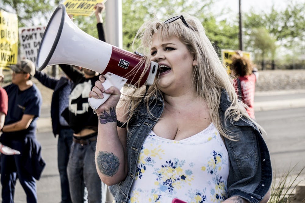 A protest organizer against the war in Syria leads a chant on a megaphone on the corner of Girard and San Mateo on Thursday, April 12, 2018. &nbsp;