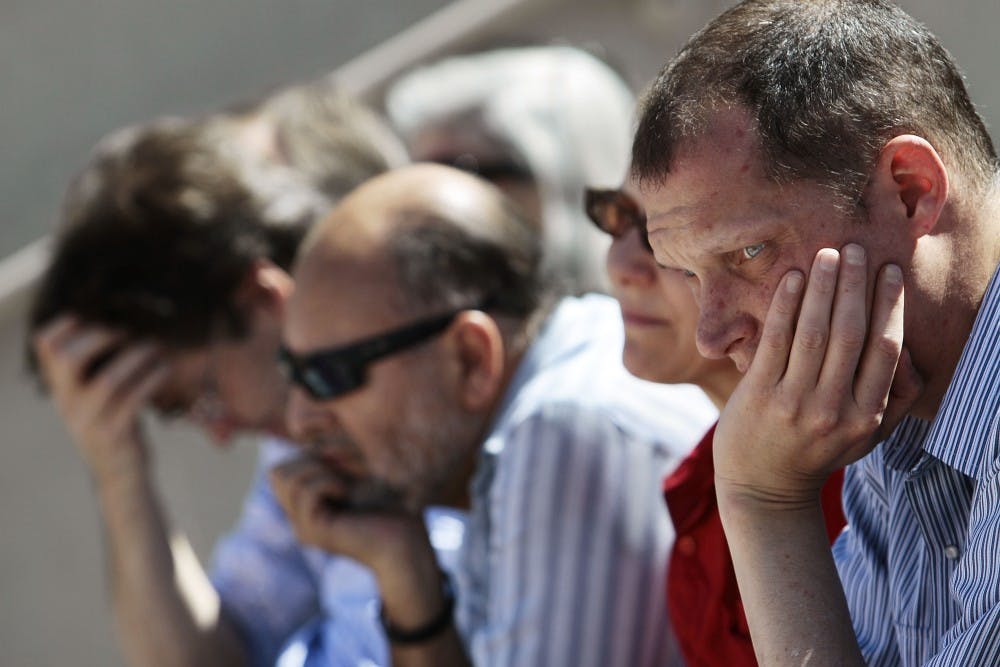	Andrew Bateman, a friend of the late UNM professor Hector Torres, sits somberly during the professor’s memorial at the National Hispanic Cultural Center on Friday. Torres was found dead in his home last month along with graduate student Stefania Gray.