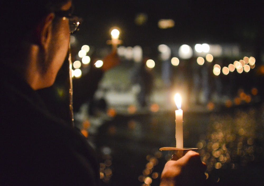 Americorp volunteer Kristoffer Sverigeson holds a candle by the Duck Pond during a Thursday night candlelight vigil honoring individuals who identify as transgender who have died in the past year. The Associated Students of UNM announced their support for the LGBTQ Resource Center for an initiative that would make it easier for students who identify as transgender to use whatever name the want for University records.