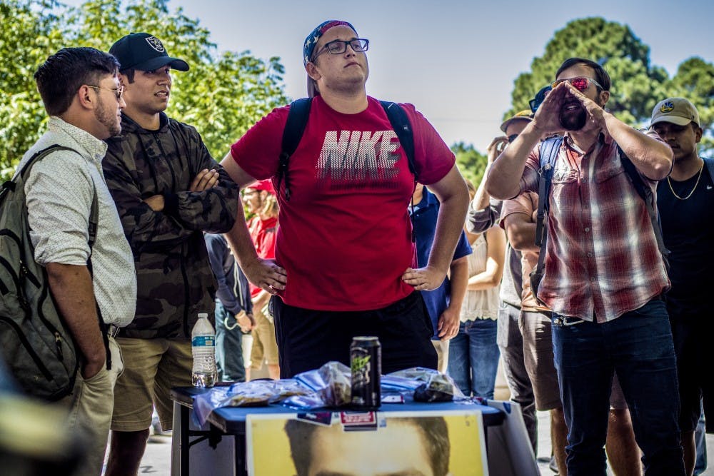Walter Baker, graduate student, right, shouts in contention to an "Affirmative Action Bake Sale" hosted by a local chapter of Turning Point USA outside the student union building, Thursday, September 21, 2017. The student group hosted the bake sale which charged patrons according to their ethnicity.