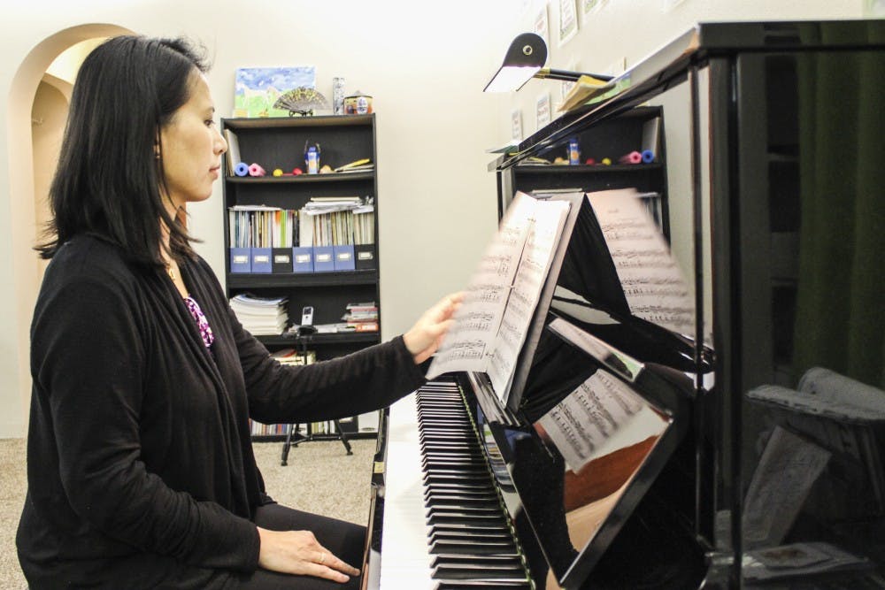 Lorraine Ho flips through her music book on Tuesday, Feb. 7, 2017 at her home studio. Ho teaches private piano lessons from her home, and will be graduating with a bachelor’s in music education this semester.