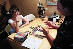 Cori Hoover gets a tarot card reading from Kirk Baldwin of Crystal Dove Inc., a shop that offers psychic readings, metaphysical gifts, yoga and meditation classes.