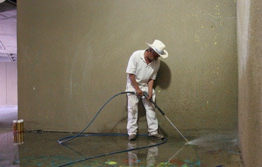 Ramon Gomez from UNM's Grounds and Landscaping department removes graffiti from the Arts and Technology Center on Wednesday.