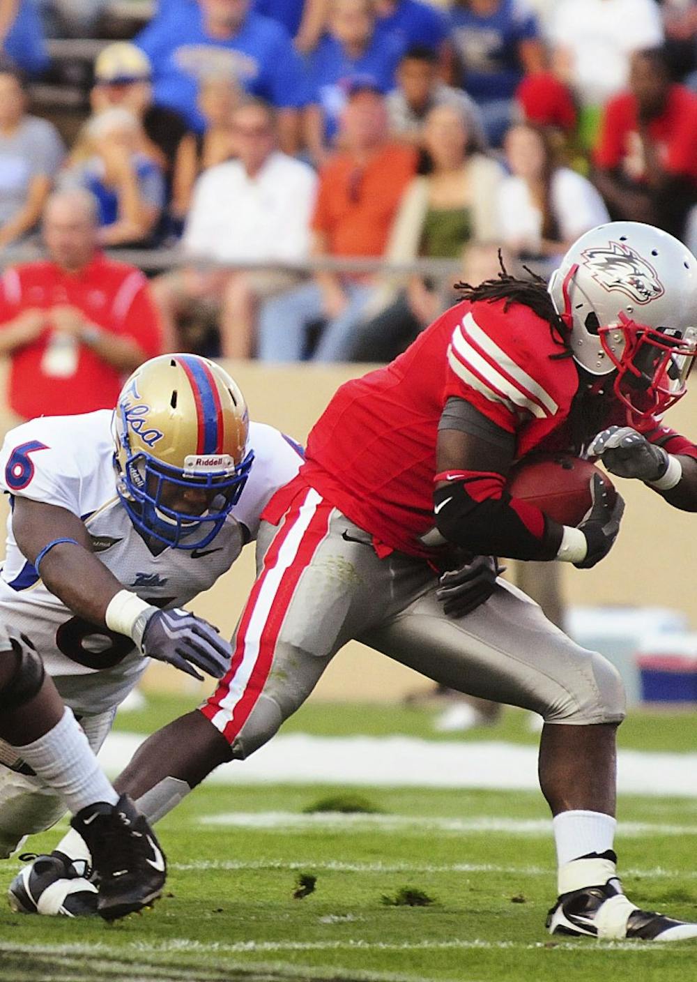 	True freshman Demond Dennis dashes past Tulsa’s Brian Moore. UNM’s running game, a staple of past Lobo squads, has been nonexistent so far this season.