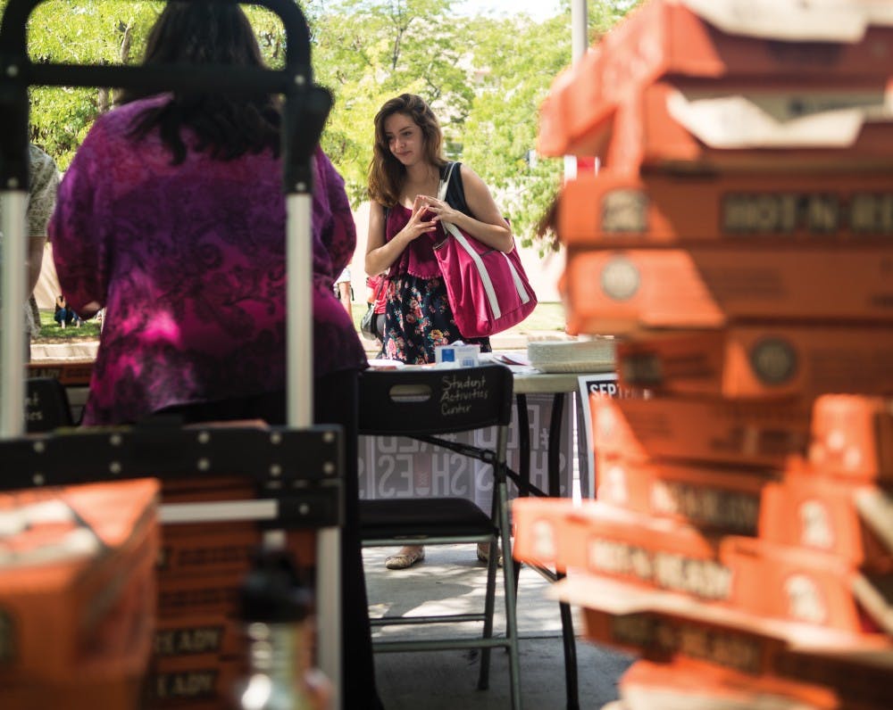 Justyna Tafoya looks at informational pamphlets laid out by CASAA during Fetal Alcohol Syndrome awareness day. Jerome Romero and other event volunteers handed out free pizza to anyone that took a short quiz at their table.