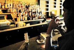 Jim Giesler, in town to work on a film, lights a cigarette at O'Niell's Pub on Friday.
