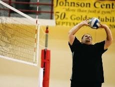 Jeff Nelson, UNM's volleyball coach, sets the ball during preseason practice Saturday before a scrimmage.