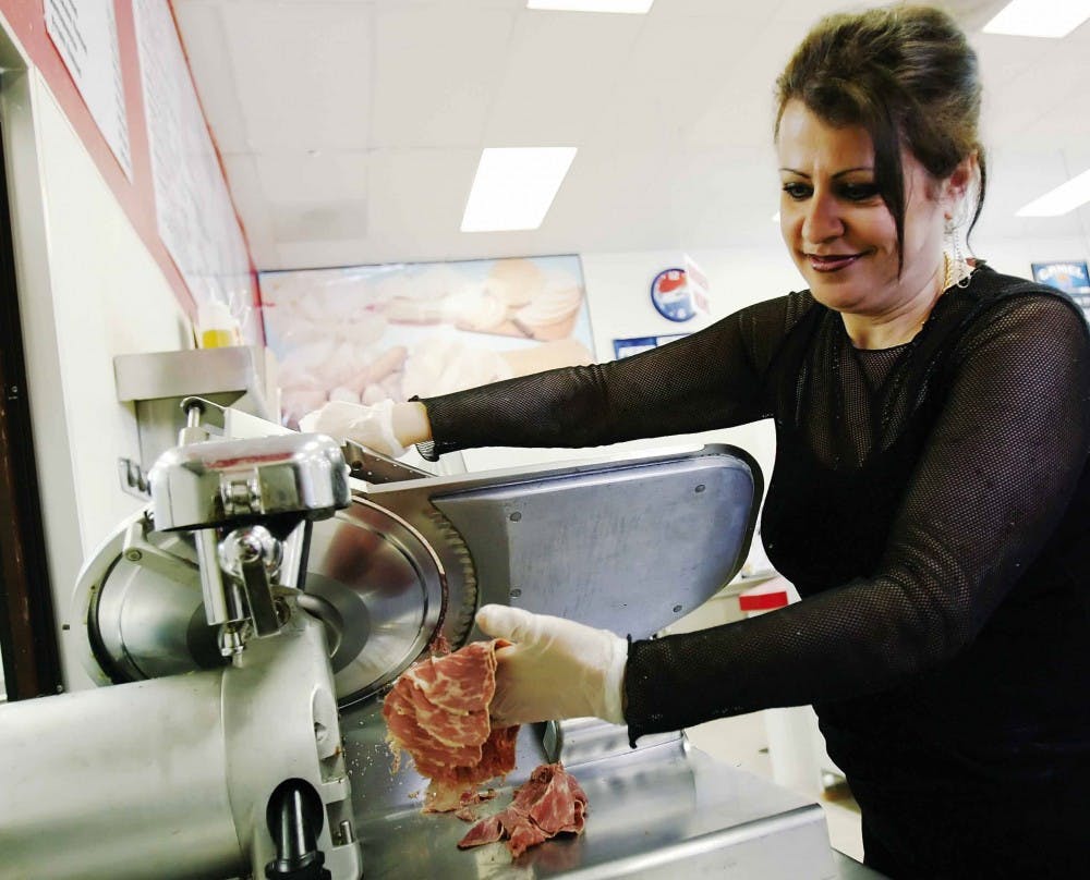 Helen Nesheiwat cuts deli meat at Times Square Deli Mart on Saturday.