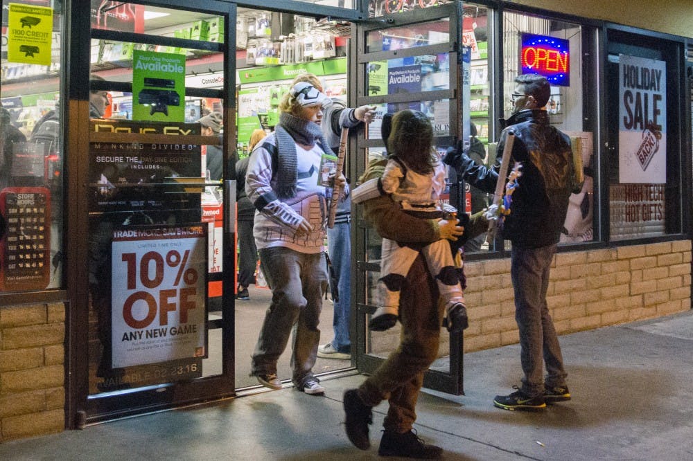 A family dressed in Star Wars attire leaves a GameStop at the late night release of Star Wars Battlefront on Nov. 17. Battlefront is a video game based in the Star Wars universe.