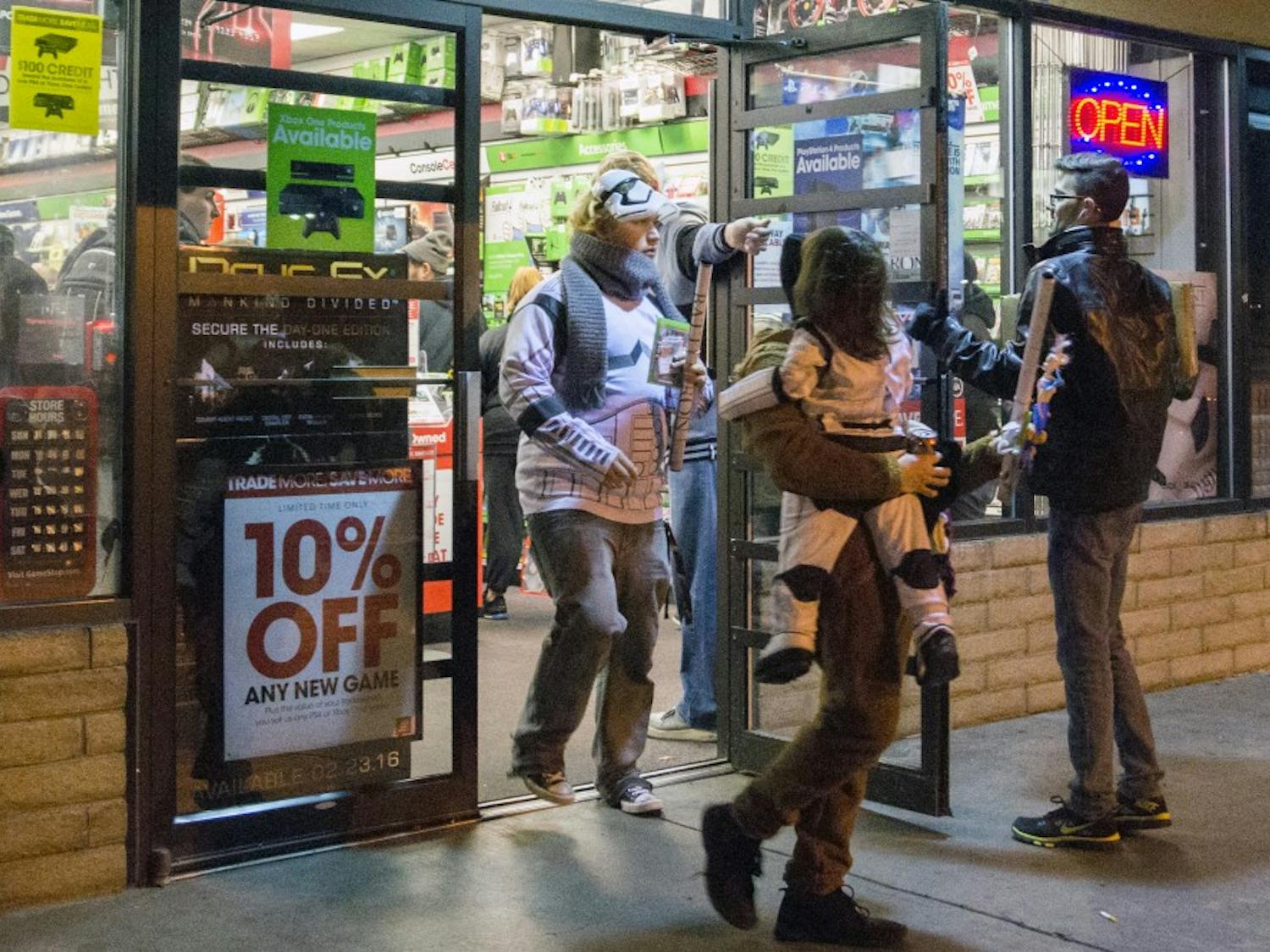 A family dressed in Star Wars attire leaves a GameStop at the late night release of Star Wars Battlefront on Nov. 17. Battlefront is a video game based in the Star Wars universe.