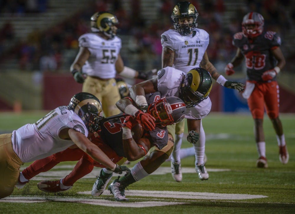 Richard McQuarleyholds&nbsp; onto the ball while being sacked by Max McDonald, left, and Arjay Jean during the televised game against Colorado State University at Dreamstyle Stadium, October 20, 2017. The Lobos were defeated 27-24 in the Friday night Mountain West match-up.