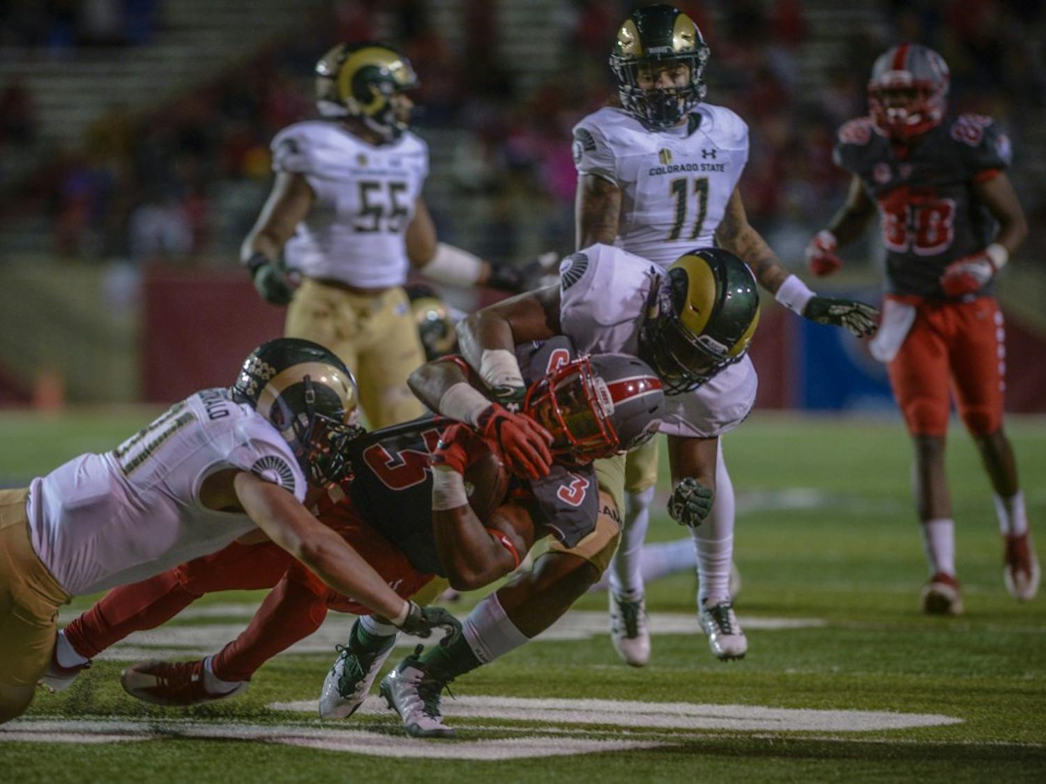 Richard McQuarleyholds&nbsp; onto the ball while being sacked by Max McDonald, left, and Arjay Jean during the televised game against Colorado State University at Dreamstyle Stadium, October 20, 2017. The Lobos were defeated 27-24 in the Friday night Mountain West match-up.