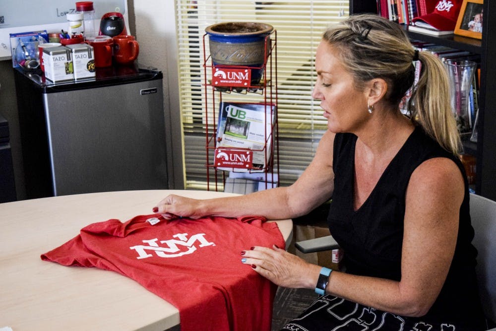 University Communications and Marketing employee, Cinnamon Blair, reveals UNM?s new logo on UNM merchandise on Aug. 29, 2017. The UNM logo will now appear on UNM merchandise along with the familiar lobo logo.