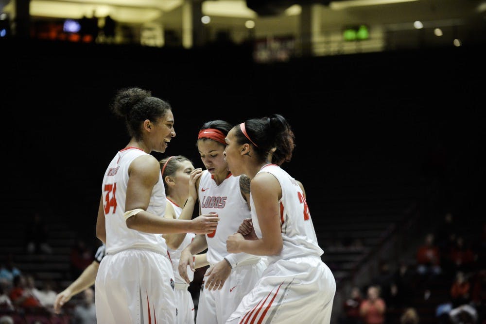 Redshirt junior center Whitney Johnson (34) and sophomore guard Jayda Bovero (24) celebrate around their teammates after scoring Wednesday night at WisePies Arena. UNM beat UNLV 67-53.