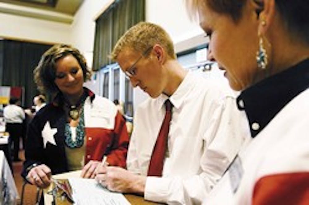 UNM student Ryan Nelson, center, talks to Mansfield Independent School District elementary principal Debbie Clayton, left, and MISD human resources director Joyce Roberts during a school employment fair held in the SUB on Thursday.