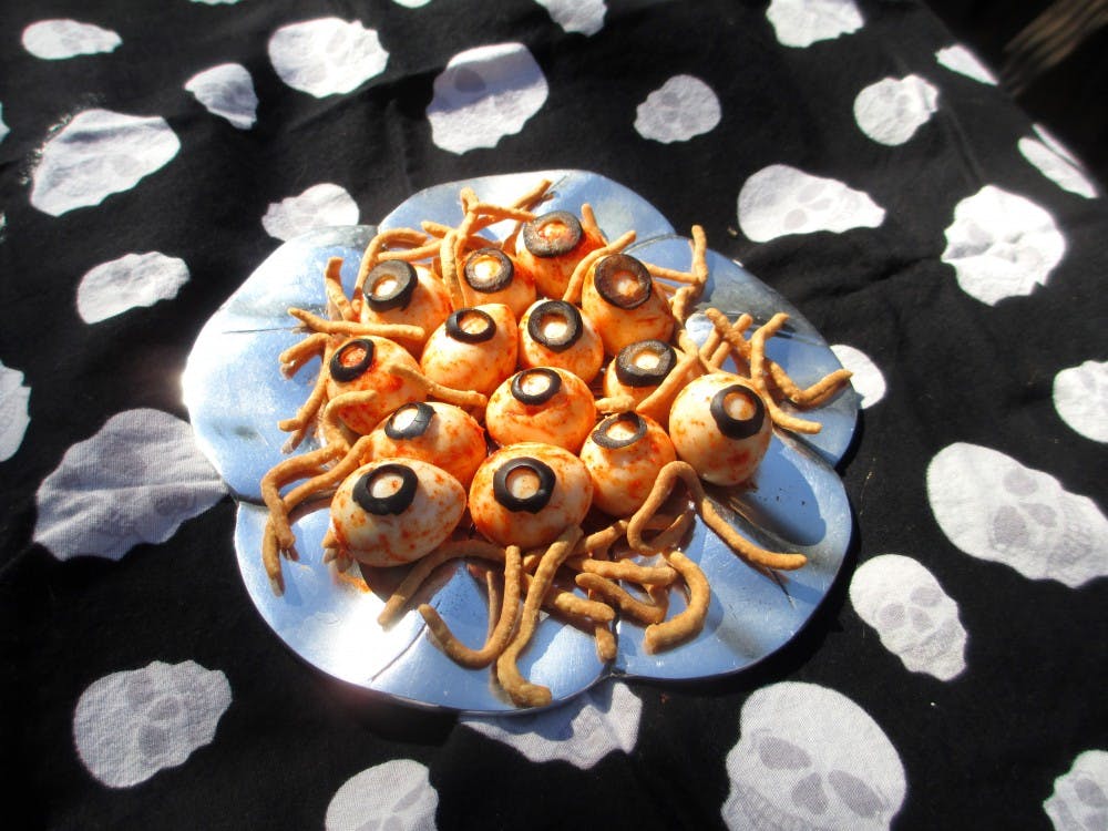 Blood-shot eyeball appetizers (eggs tossed in paprika and dressed up with black olive slices).