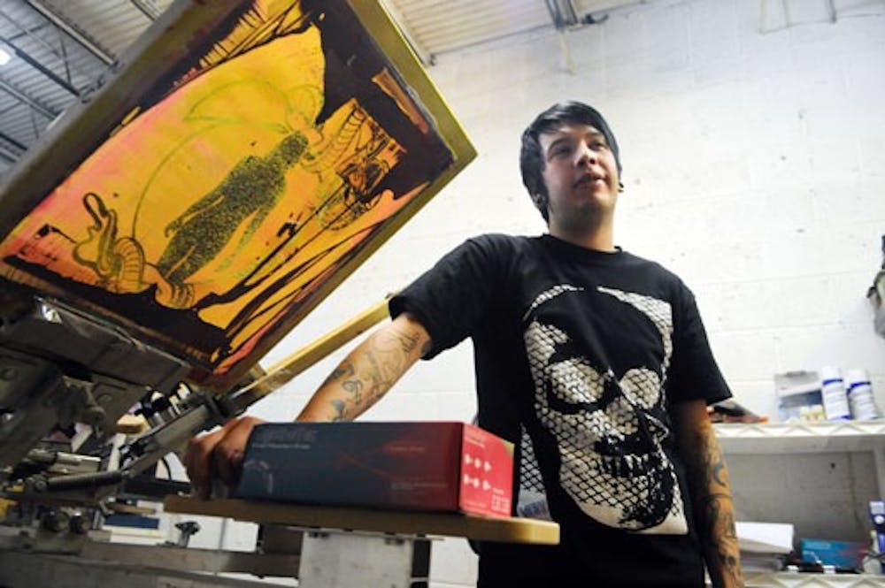 Simone Sierra stands by a silkscreen press at Rival Tattoo Art Studios on Tuesday. The shop is launching its own clothing line.