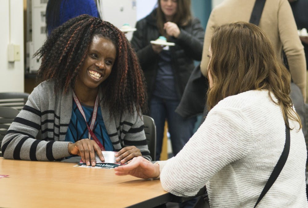 CAPS tutors Emillia Masaka, right, a third-year Ph.D. student, and Tana Moore, left, a speech and hearing science student, chat during the grand opening of the CAPS Writing and Language Center on Jan. 14. The center, located in Education classrooms 208 and 210, helps students with writing and foreign languages.