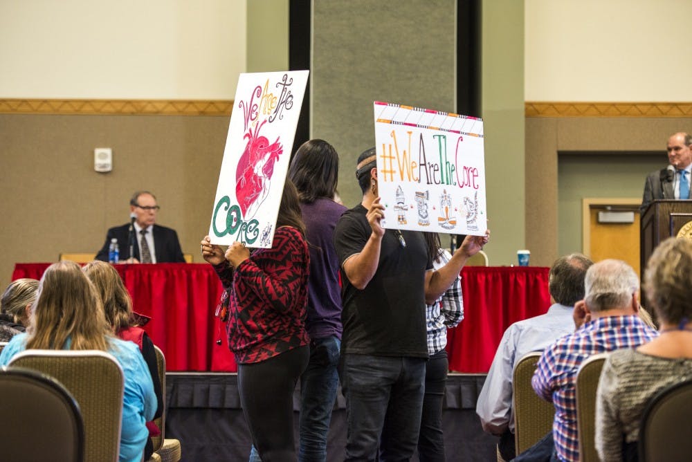 Trisha Martinez and Cody Artis speak at the mic while two others hold signs during a UNM Town Hall in the SUB Ballroom on Friday, Oct. 21, 2016. President Bob Frank addressed attendees about the current hiring freeze and budget issues.