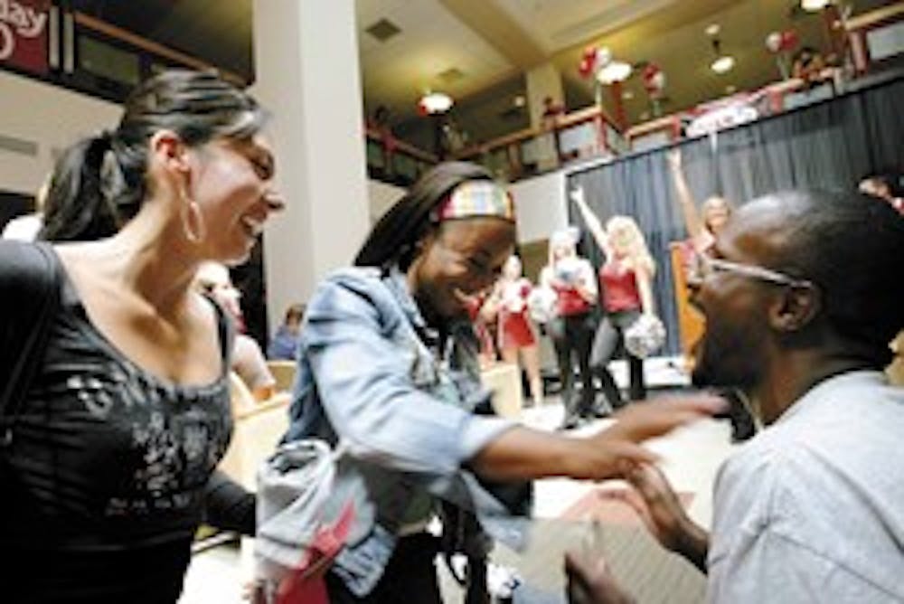 Nikiyah Gill, center, shares a laugh with Jay Tillman and Valerie Martinez in the SUB on Thursday after the announcement that students will be able to get free tickets for men's basketball games at The Pit this season.