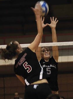 UNM middle blocker Joelle Ingram blocks a spike from NMSU middle hitter Anna Callis during Monday night's match in Johnson Gym. The Lobos lost 3-0.