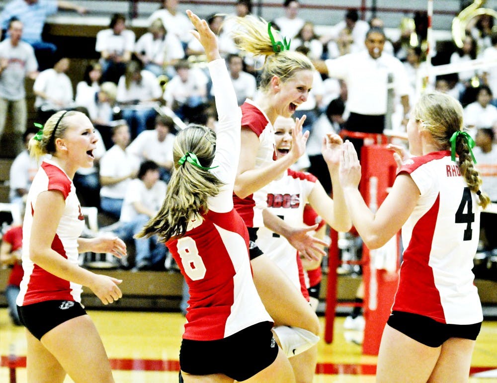 	Allison Buck , No. 8, and Ashley Rhodes, No. 4, celeberate with teammates during their victory over in-state rival New Mexico State Tuesday night at Johnson Gym. The Lobos came back froma one-set deficit to win the match.