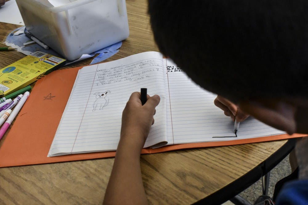 An elementary school English as a second language student writes during class.