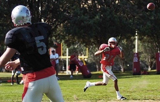 Lobo quarterback Chris Nelson throws a pass to wide receiver Travis Brown during practice Thursday at Lobo football practice field.  