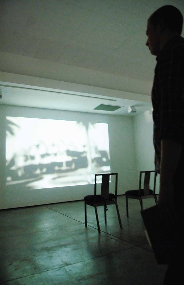 Bryan Kaiser, educational coordinator for 516 Arts, watches Jeremy Blake's "Winchester" video Tuesday at 516 Arts. The video is part of an international exhibit called "Ghosts in the Machine."