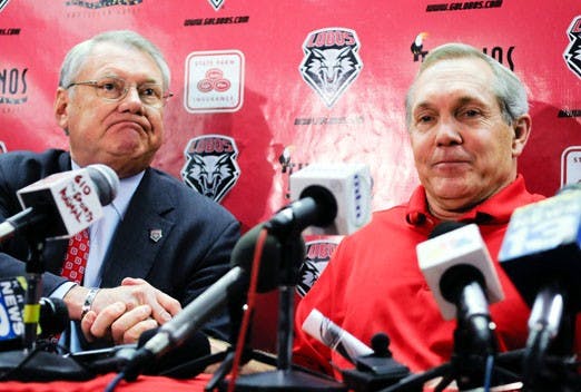 Football head coach Rocky Long, right, shakes hands with President David Schmidly after announcing his resignation during a press conference at the Pete McDavid Lounge on Monday.