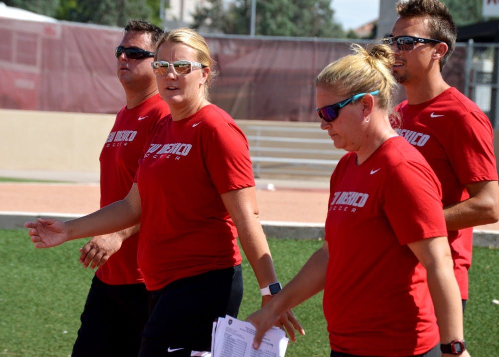 UNM head women’s soccer coach Heather Dyche, second from left, walks to the field with her assistants.&nbsp;