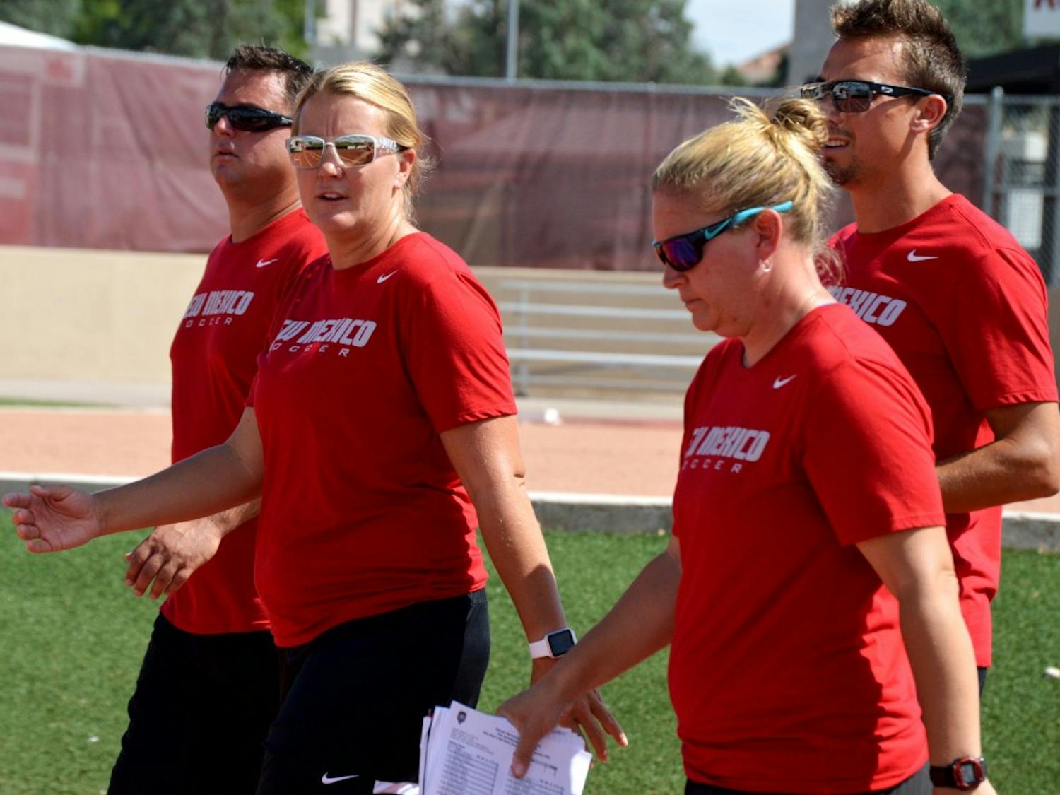 UNM head women’s soccer coach Heather Dyche, second from left, walks to the field with her assistants.&nbsp;