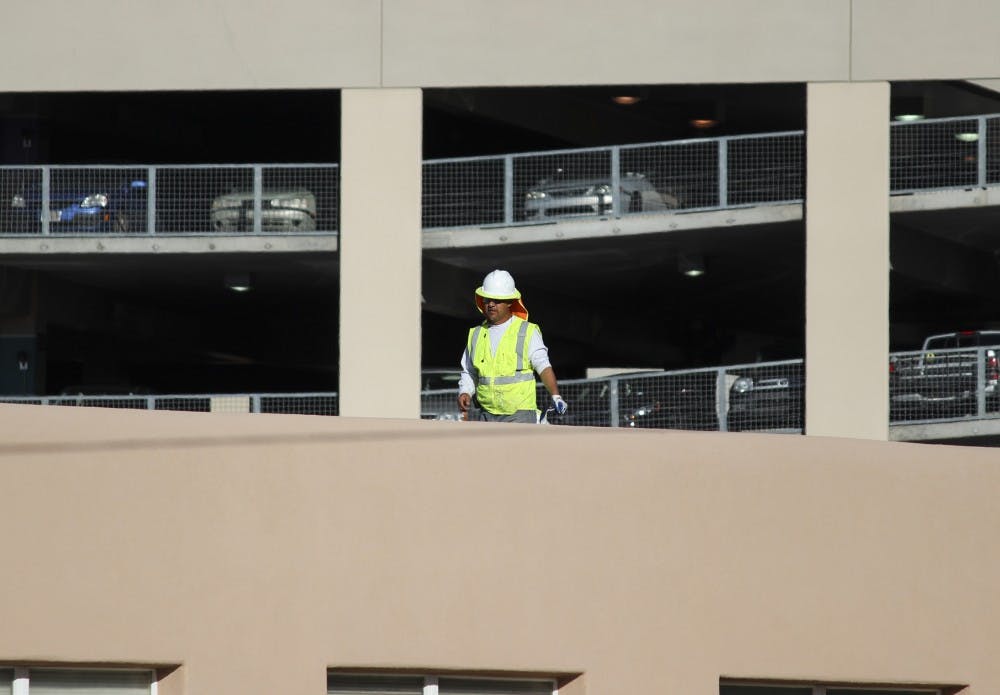A maintenance worker fixes mastic lab seams on a parapet at the Physics and Astronomy rooftop on Tuesday afternoon. If state Senate Bill 159 passes, the old Physics and Astronomy building on Lomas Boulevard could be replaced with a new, state-of-the-art Interdisciplinary Science Building.