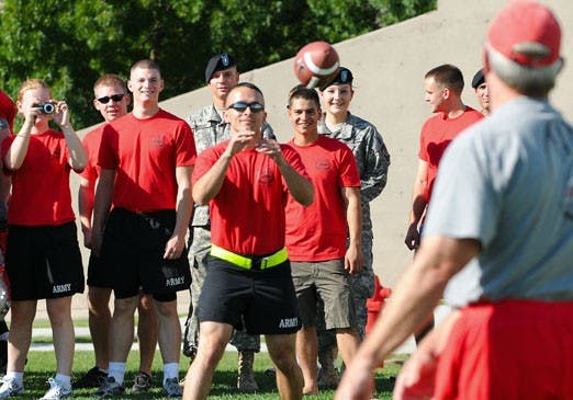 Lobo football coach Rocky Long tosses Saturday's game ball to head Army cadet Luis Sanchez at the UNM Practice Field on Wednesday. 