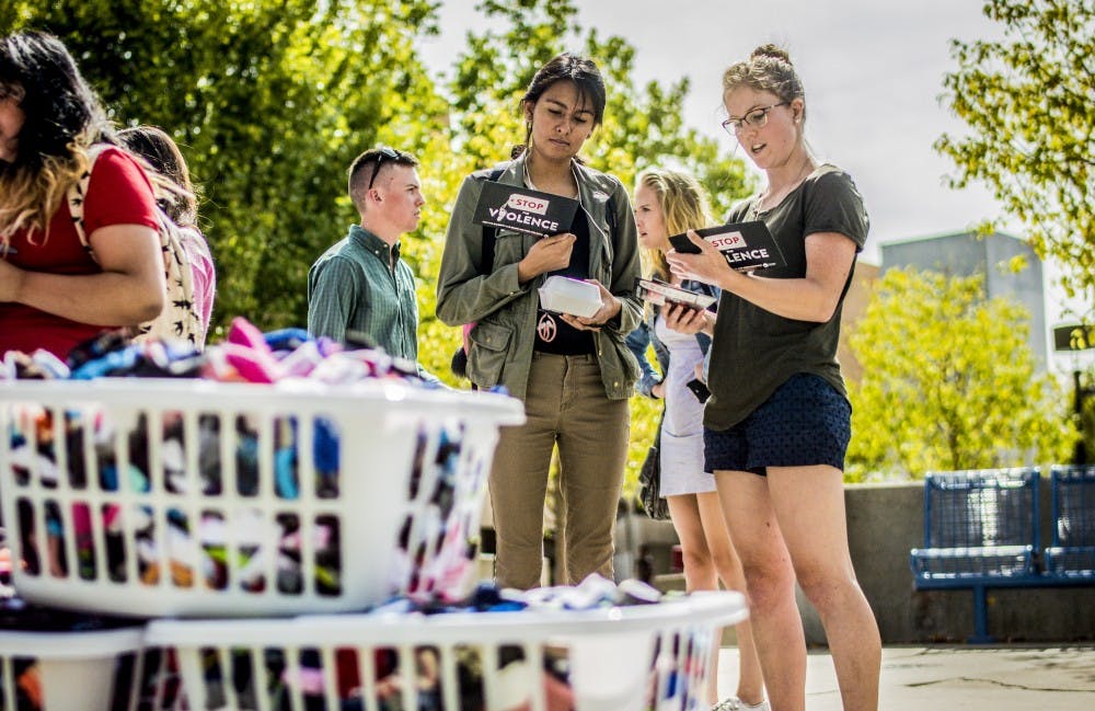 Kassidy Steckbeck, right,&nbsp;member of Students for Life UNM, shares information with Alma Lozano near the UNM Duck Pond, Friday, Sept. 22, 2017.  Students for Life UNM held the tabling event, "Stop the Violence," Friday to provide information and resources addressing abortion as an act of violence, using the hampers in the foreground filled with 6,276 infant socks to represent&nbsp;the amount of abortions performed at Planned Parenthood during a normal work week.