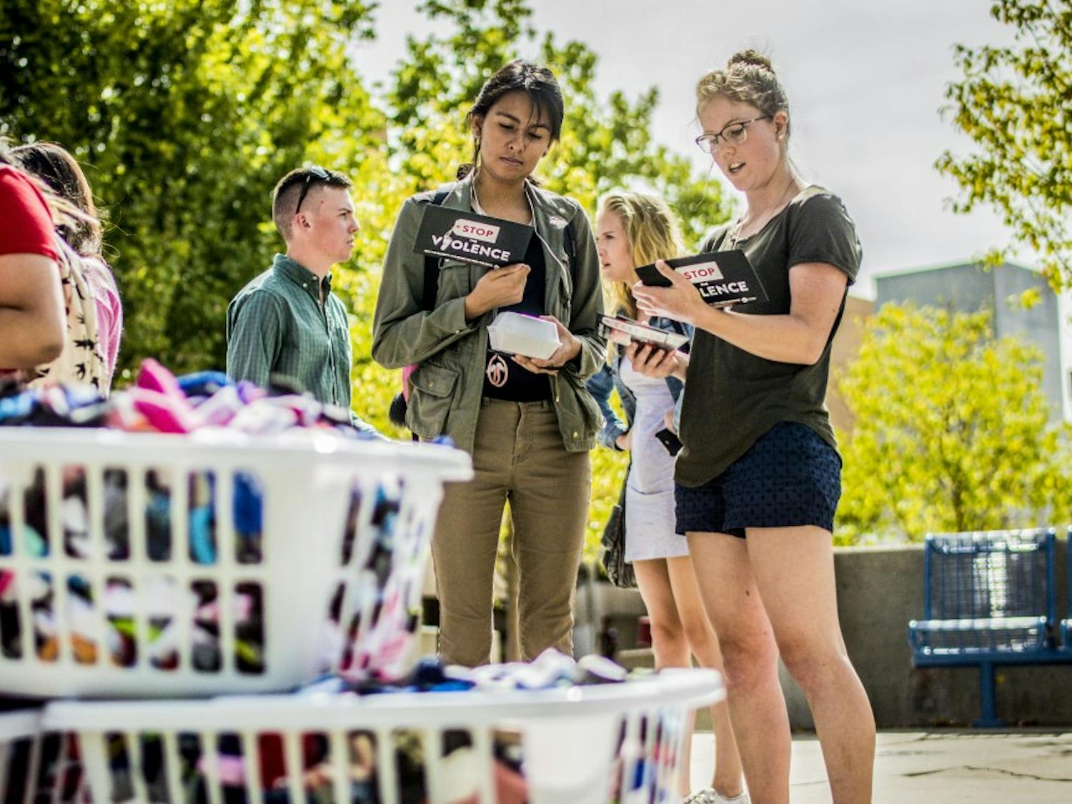 Kassidy Steckbeck, right,&nbsp;member of Students for Life UNM, shares information with Alma Lozano near the UNM Duck Pond, Friday, Sept. 22, 2017.  Students for Life UNM held the tabling event, "Stop the Violence," Friday to provide information and resources addressing abortion as an act of violence, using the hampers in the foreground filled with 6,276 infant socks to represent&nbsp;the amount of abortions performed at Planned Parenthood during a normal work week.