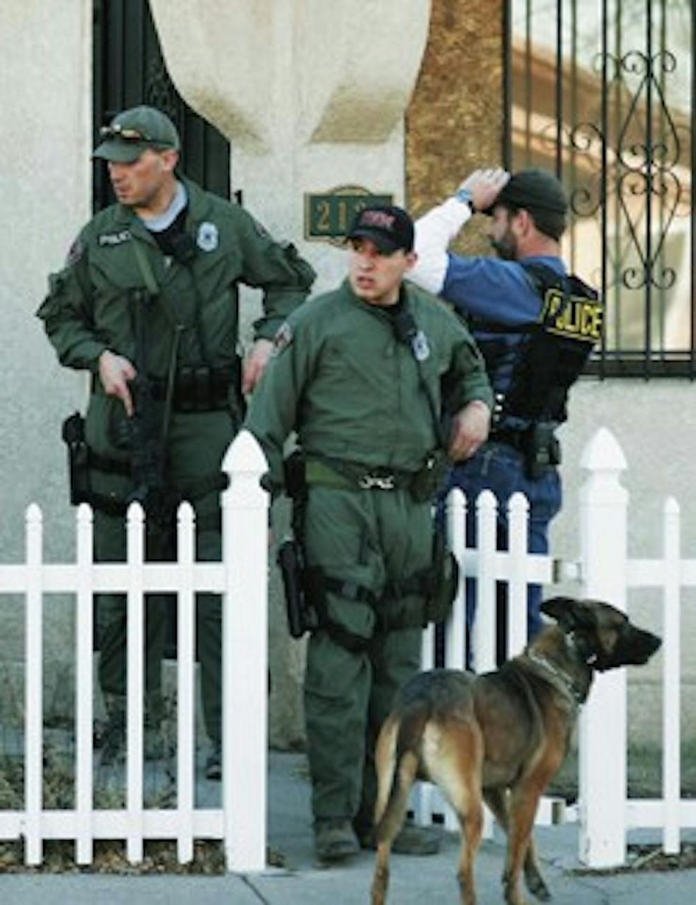 Albuquerque Police Department officers and a K-9 unit leave a home they searched in an effort to find Nicholas Blume, a wanted felon. The neighborhood of Lead Avenue and Buena Vista Drive was barricaded by police Wednesday. 