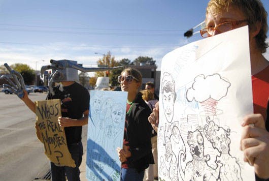 Protesters, from left, Jacob Gray, Rosie Hutchinson and Henry Hutchinson stand near the intersection of University Boulevard and Central Avenue on Sunday to protest the Republican-controlled Congress and the war in Iraq. 