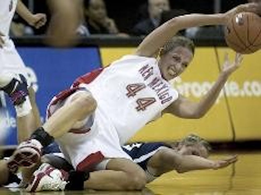 UNM center Angela Hartill and BYU forward Coriann Wood fight for a loose ball during the Lobos' 59-41 win in Las Vegas at the Mountain West Championship on Wednesday. 