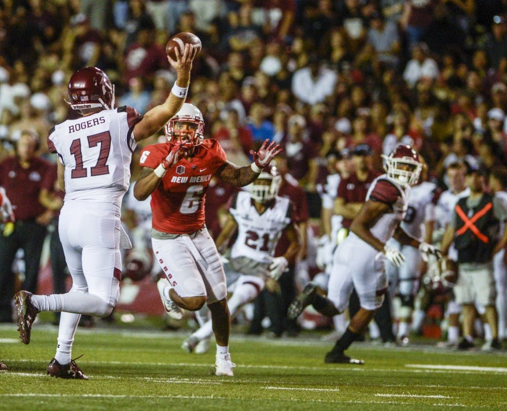 NMSU quarterback Tyler Rogers throws over Lobos Austin Ocasio to teammate Larry Rose III at Dreamstyle Stadium, Saturday, September 9, 2017.