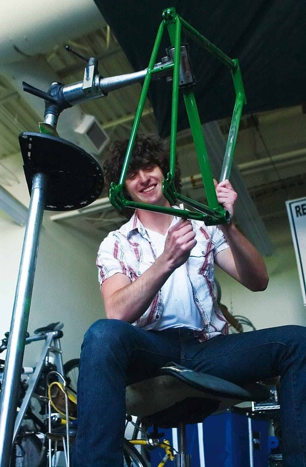 Bicycle mechanic Sean Alkire works on a bike frame in the Recreational Services Bike Shop in Johnson Center on July 20. 
