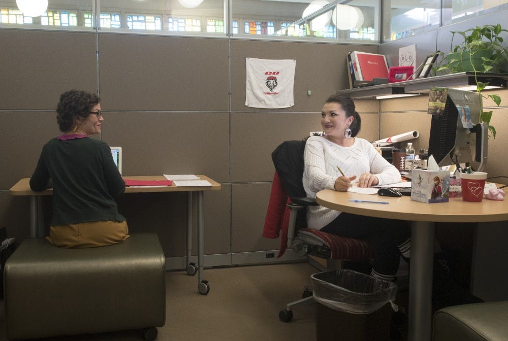 Senior academic advisors Maureen Johnson, left, and Maxine Padilla have a conversation inside one of the new cubicles at Travelstead Hall on Wednesday. The cubicles were renovated to give students privacy during advisory appointments. 
