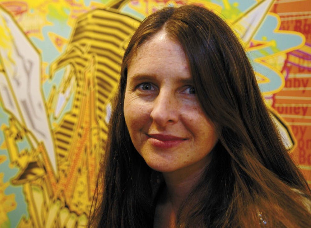 Poet Lisa Gill stands in front of "Bee," a print by local artist M.D. Williams, at Donkey Gallery on 1415 Fourth St. S.W. on Friday. 