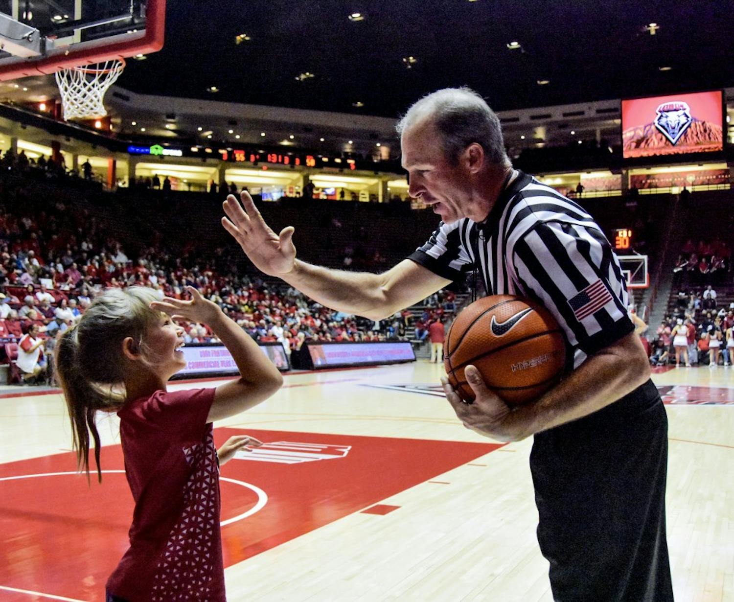 A fan and referee high five during the Lobo vs TCU game at the Dreamstyle Arena. &nbsp;