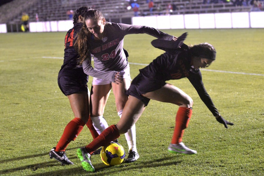 Senior forward Madisyn Olguin fights off two San Diego State players at the UNM Soccer Complex Friday night. The Lobos lost to San Diego State 2-1 and will begin play in the Mountain West tournament Tuesday against UNLV.