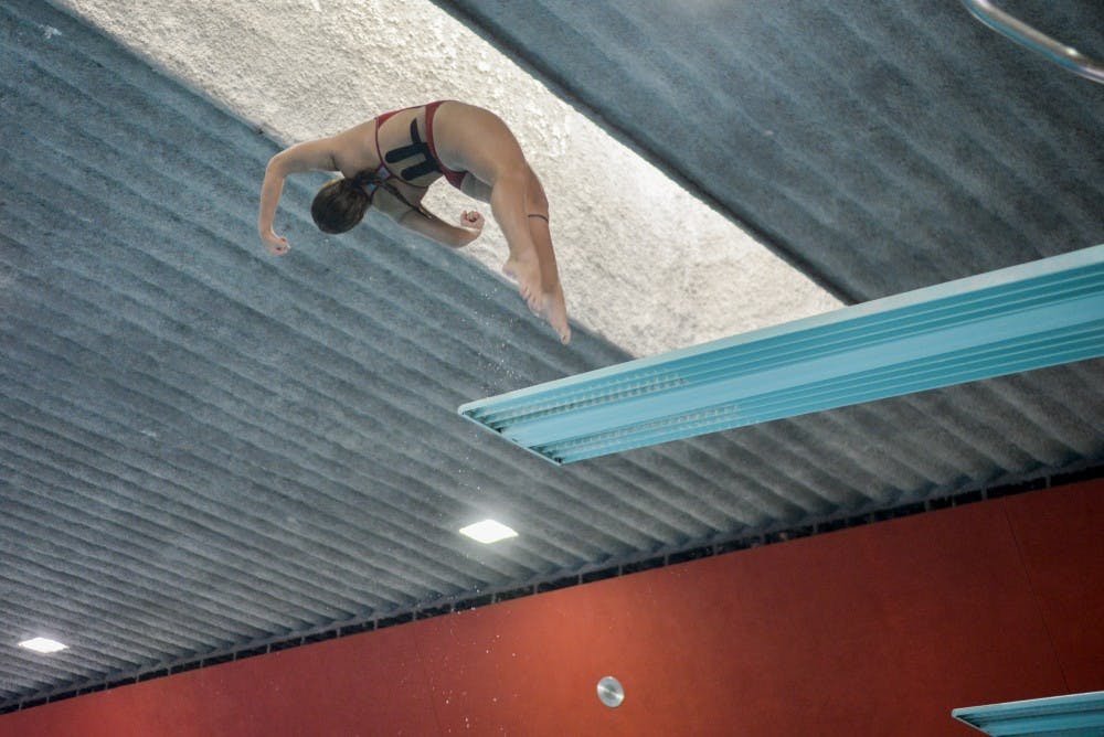 Freshman diver Allyson Concepcion spins through the air after leaving the 3-meter diving board Saturday at the Seidler Natatorium. The Lobos beat the Aggies 153-142.